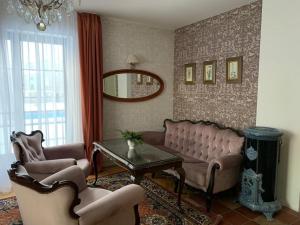 a living room with couches and a table and a mirror at Hotel Usadba in Kaliningrad