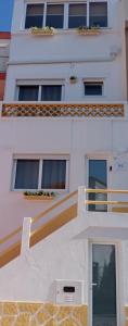 a white building with a staircase and windows at CASA do BATORÉU - BUARCOS 120 MT PRAIA in Figueira da Foz