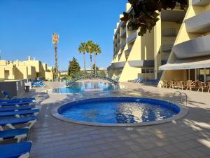 a large swimming pool next to a building at Condominio do Mar in Lagos