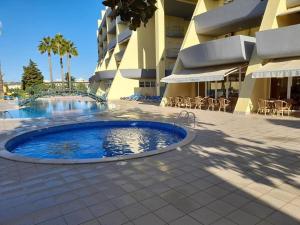 a large swimming pool in front of a building at Condominio do Mar in Lagos