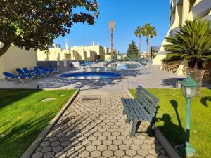a park bench and a light next to a pool at Condominio do Mar in Lagos