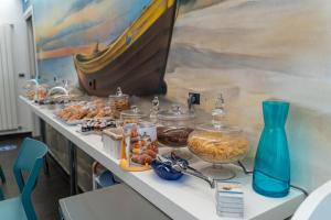 una mesa con comida y un jarrón azul. en Oltremare Giovino, en Catanzaro