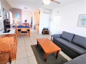 uma sala de estar com um sofá e uma mesa em Summer Rocks A em Margate