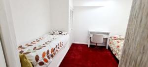 a small bedroom with a bed and a red carpet at Olly’s place in Manchester