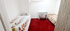 a small room with two beds and a red carpet at Olly’s place in Manchester