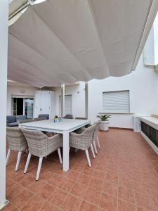 a dining room with a white table and chairs at Oltremare Giovino in Catanzaro