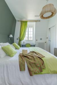 a bedroom with a large white bed with green accents at L'Hôtel Particulier - Paris Asnières in Asnières-sur-Seine