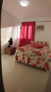 1 dormitorio con 1 cama con colcha de flores y ventana en Residêncial primavera, en Recife