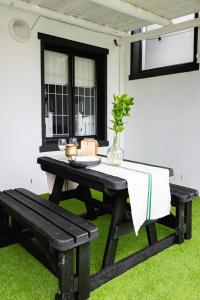 a picnic table and bench on the grass at Villa Le Roc Kleinmond Accommodation in Kleinmond