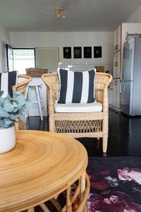 a living room with a table and wicker chairs at Villa Le Roc Kleinmond Accommodation in Kleinmond