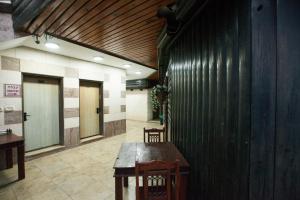 um corredor com uma mesa de madeira e cadeiras num edifício em מלון אחוזת האושר em Tiberíades