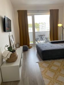 a bedroom with a bed and a table and a window at Anca Alphaville III in Braşov