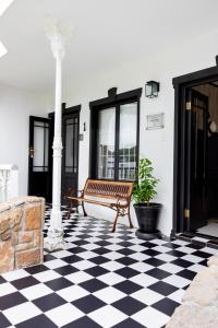 a bench sitting on a checkered floor on a house at Villa Le Roc Kleinmond Accommodation in Kleinmond