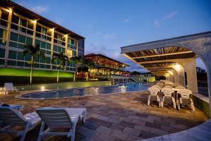 a group of chairs sitting next to a pool at Villa Hípica Resort in Gravatá