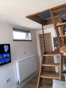 een kamer met een ladder en een tv aan de muur bij Piala retreat in Phillack