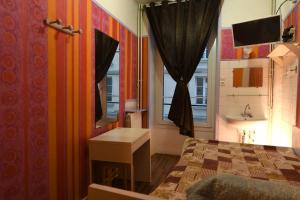 a bedroom with a bed and a sink and a window at Hotel d'Orl&eacute;ans Paris Gare de l'Est in Paris