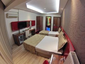 a hotel room with two beds and a television at Anil Hotel in Bergama