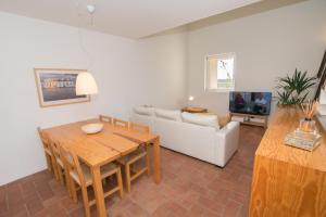 a living room with a table and a white couch at Convento das Bernardas By Algartur (AL) in Tavira