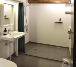 a bathroom with a sink and a mirror at Hotel Steenbergs in Nykøbing Mors +45 photos