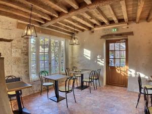 een eetkamer met tafels, stoelen en ramen bij Logis Hôtel du Cygne in Bracieux