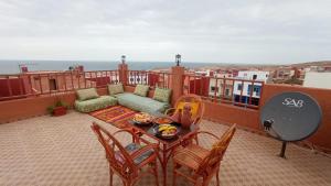 a balcony with a couch and a table and chairs at Brothers house 4 in Imsouane
