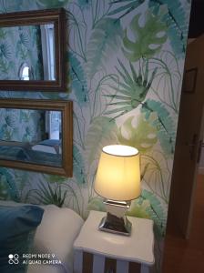 una lámpara en una mesa frente a una pared con plantas en Alojamiento Buciero en Santoña