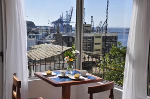 a dining room table with a window overlooking a city at AYCA La Flora Hotel Boutique in Valparaíso