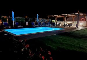 una piscina por la noche con sillas y cenador en Aqui n' al-deia en Mértola