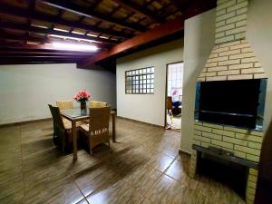 Una sala de estar con una mesa y una chimenea. en Recanto Rafaella, en Olímpia