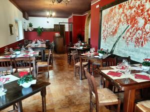 a restaurant with tables and chairs in a room with red walls at Il Cantico delle Cicale in Piccione
