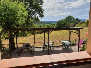 a deck with a picnic table and a bench at La maison de Lalouette in Forcalquier