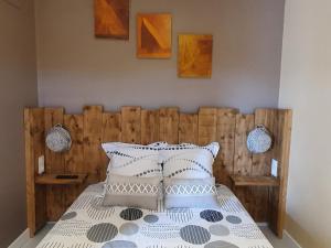 a bedroom with a bed with a wooden headboard at La maison de Lalouette in Forcalquier