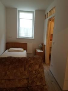 ein kleines Schlafzimmer mit einem Bett und einem Fenster in der Unterkunft Ferienwohnung Wacker, Apartments und Zimmer in Züschen