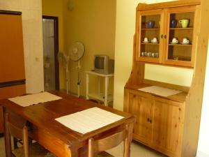a dining room with a wooden table and a cabinet at Agriturismo Tenuta La Siesta in Gallipoli