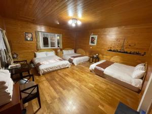 2 camas en una habitación con paredes de madera en 桃山渡假農場, en Fuxing