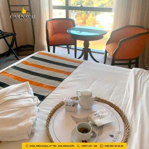 a tray with a cup of coffee on a bed at Carnaval Hotel Casino in Encarnación