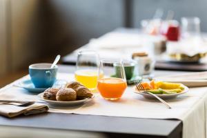 une table avec des assiettes de nourriture et des verres de jus d'orange dans l'établissement La Villa, à Pieve a Nievole
