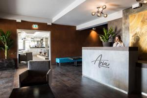 a woman sitting at a counter in a lobby at La Villa in Pieve a Nievole