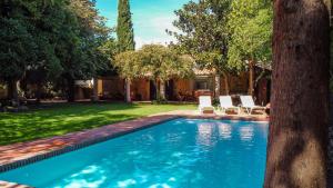 a swimming pool in a yard with two lounge chairs at El huerto de Candeleda in Candeleda