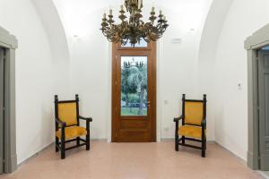 een hal met 2 stoelen en een kroonluchter bij RIAMA AGRIRESORT in Napels