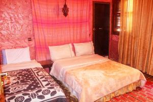 a bedroom with two beds in a room at Auberge et hôtel les amis tafraout in Tafraoute +6 photos