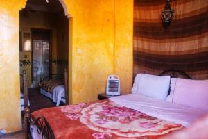 um quarto com uma cama com colcha floral em Auberge et hôtel les amis tafraout em Tafraout