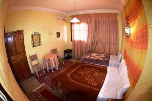 1 dormitorio con 1 cama grande y 1 mesa en Auberge et hôtel les amis tafraout, en Tafraoute