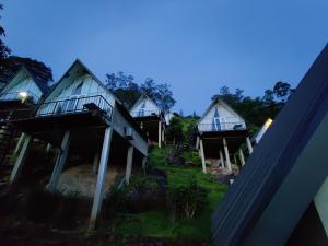 uma fila de chalés numa colina à noite em St.Clair Villas em Dimbula