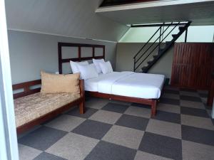 a bedroom with a bed and a couch and a staircase at St.Clair Villas in Dimbula