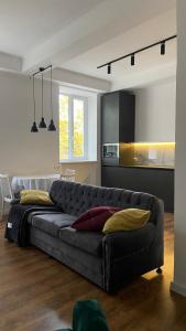 a living room with a black couch and a kitchen at Sobornosti Apartment Poltava City in Poltava
