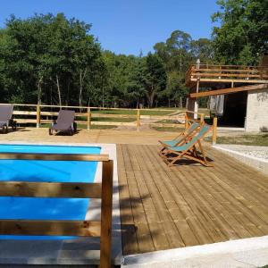 a wooden deck with a pool and chairs on it at QUINTA DO VALE in Valença