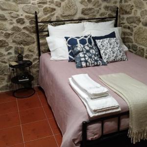 a bed with towels and pillows on top of it at QUINTA DO VALE in Valença