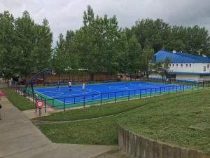 two people playing tennis on a tennis court at Apartman River in Sremska Mitrovica
