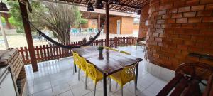 - une table et des chaises sur une terrasse avec un hamac dans l'établissement Casa de campo em Gravatá, à Gravatá